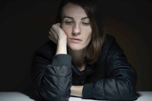 depressed woman sitting at a table